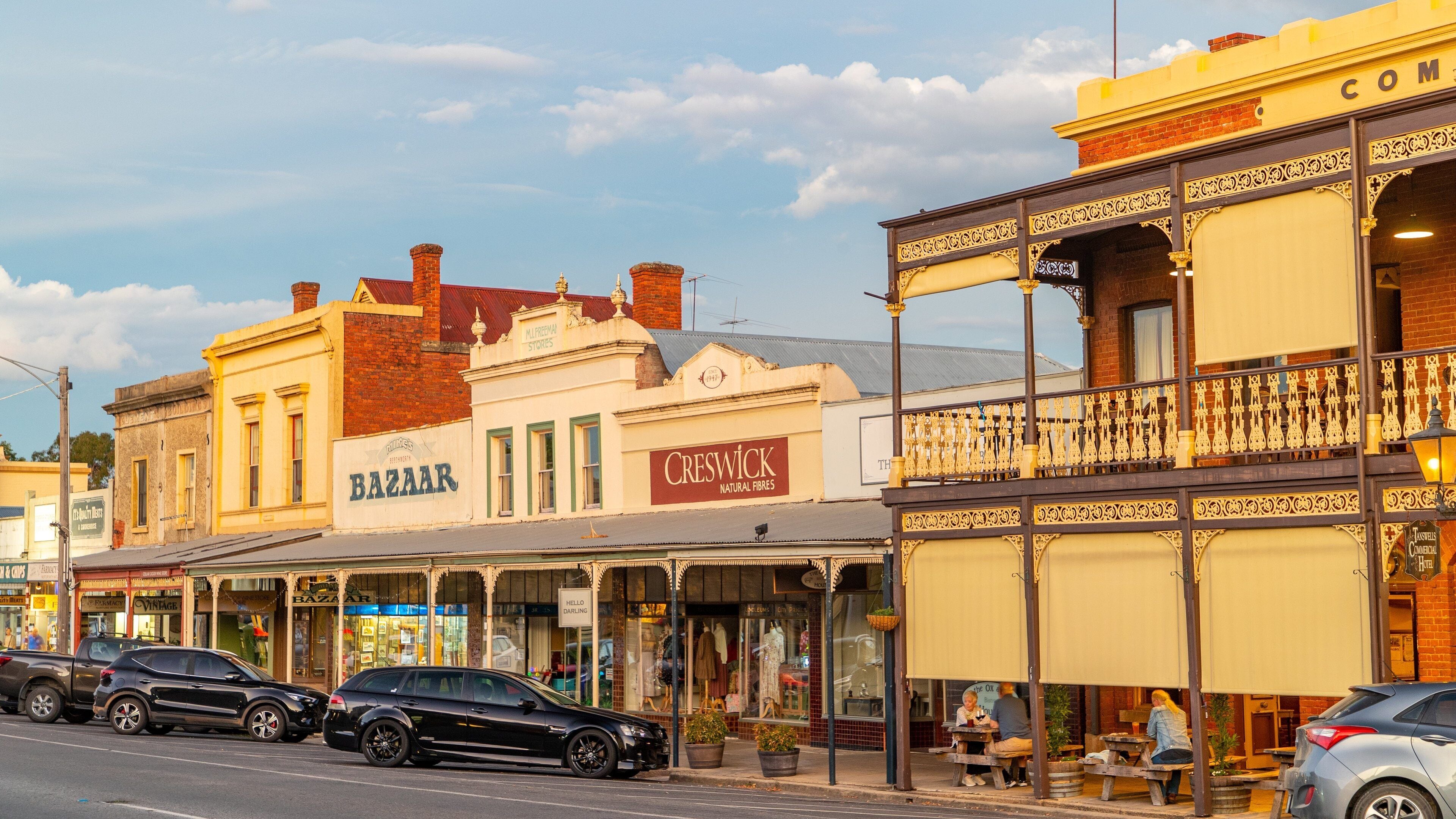 A street with vintage buildings, including a bazaar and a natural fibers store.