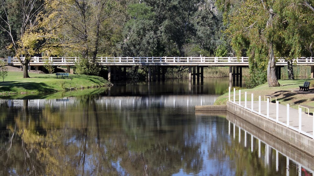 Lake of water with trees and a bridge at Seven Creeks Park in Euroa, Victoria, Australia