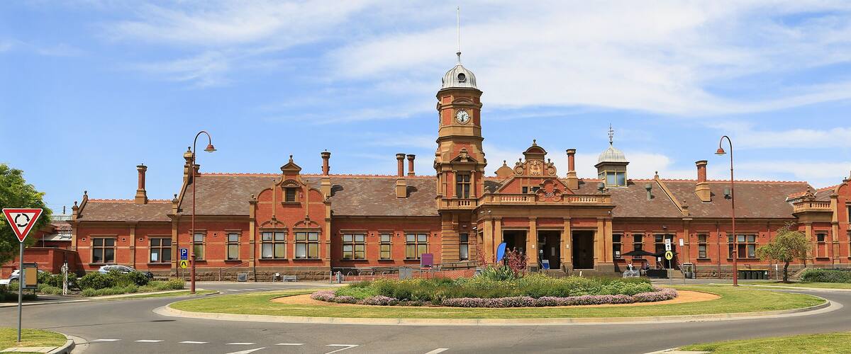 A large, historic building with a prominent clock tower and arched windows.