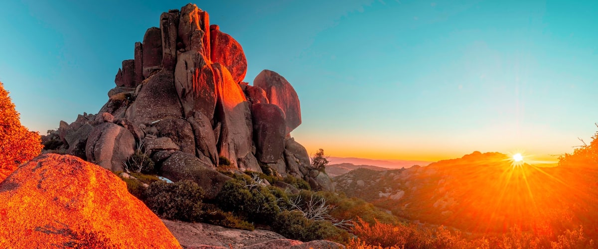 A rocky mountain landscape with a sunset.