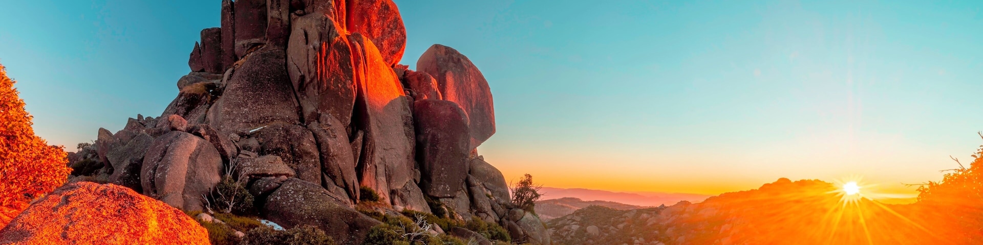 A rocky mountain landscape with a sunset.