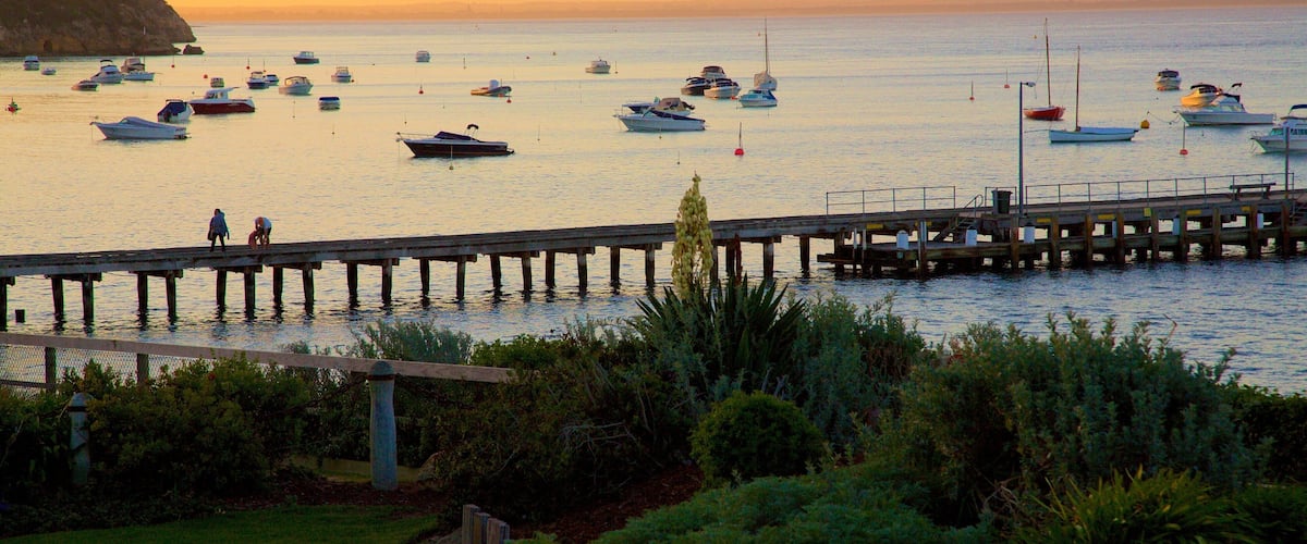 A marina with boats docked at a pier during sunset.