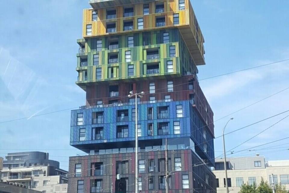 A multi-story building with a unique stacked design, featuring various colors and windows.