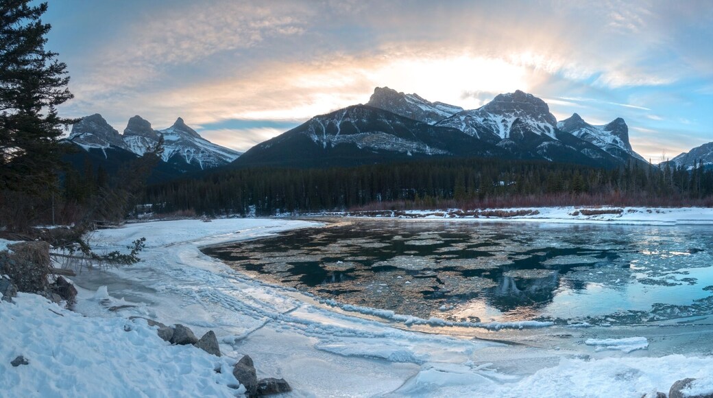 Wide Panoramic Landscape of Bow River and Mountain Peaks on a cold winter day near Canmore, Alberta in Canadian Rockies