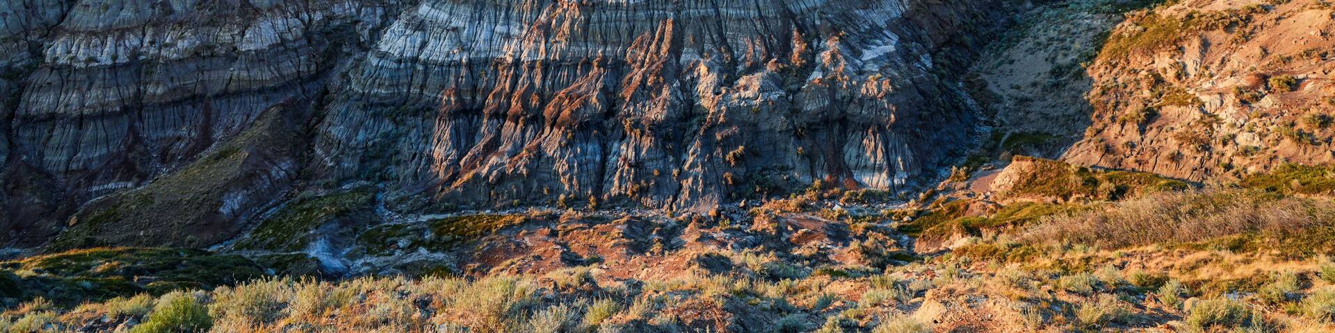 A rugged landscape with layered rock formations and sparse vegetation.
