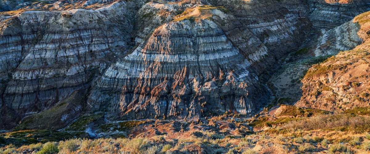 A rugged landscape with layered rock formations and sparse vegetation.