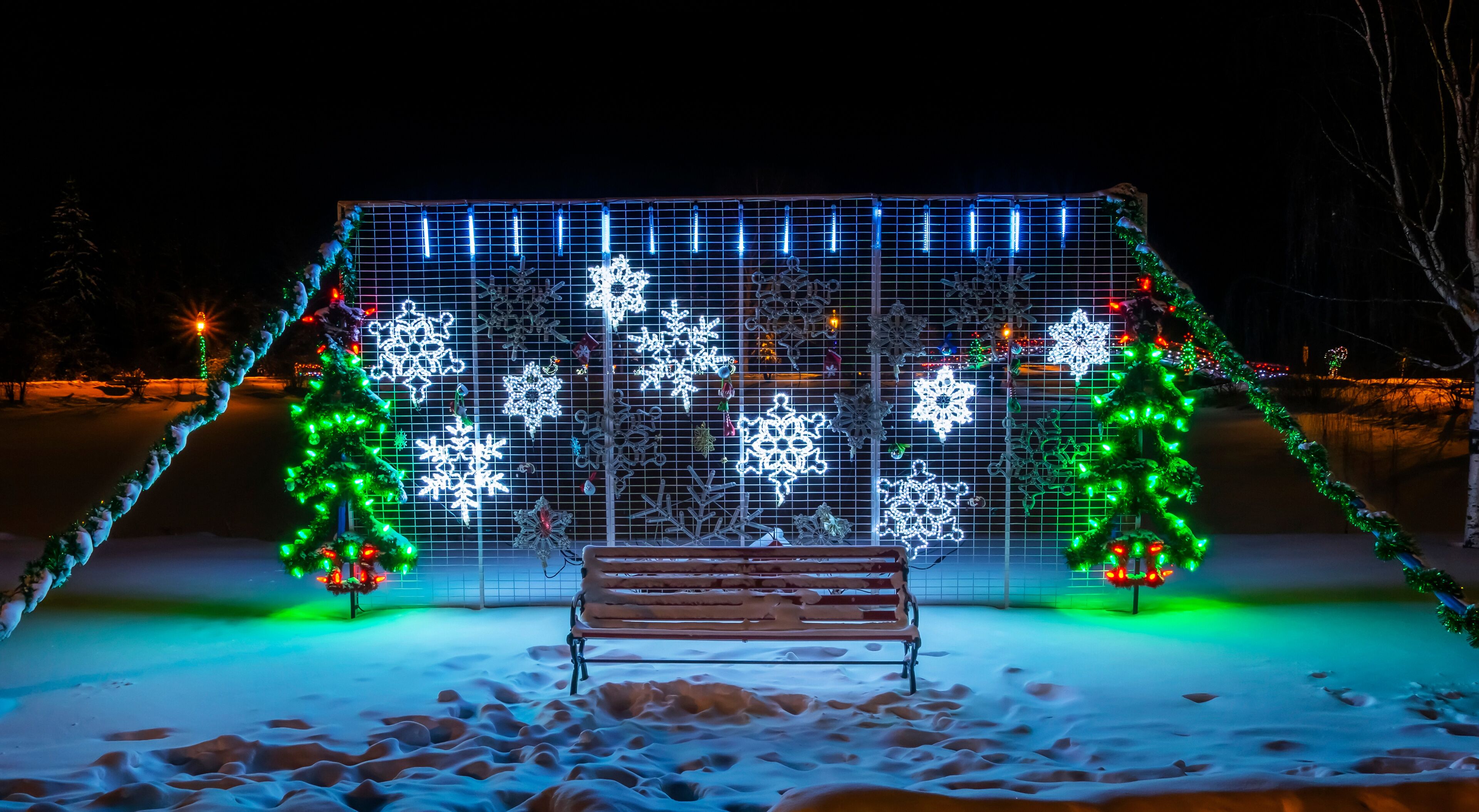 Christmas lights illuminate a decorative display at night in a snowy park in winter; Stony Plain, Alberta, Canada
