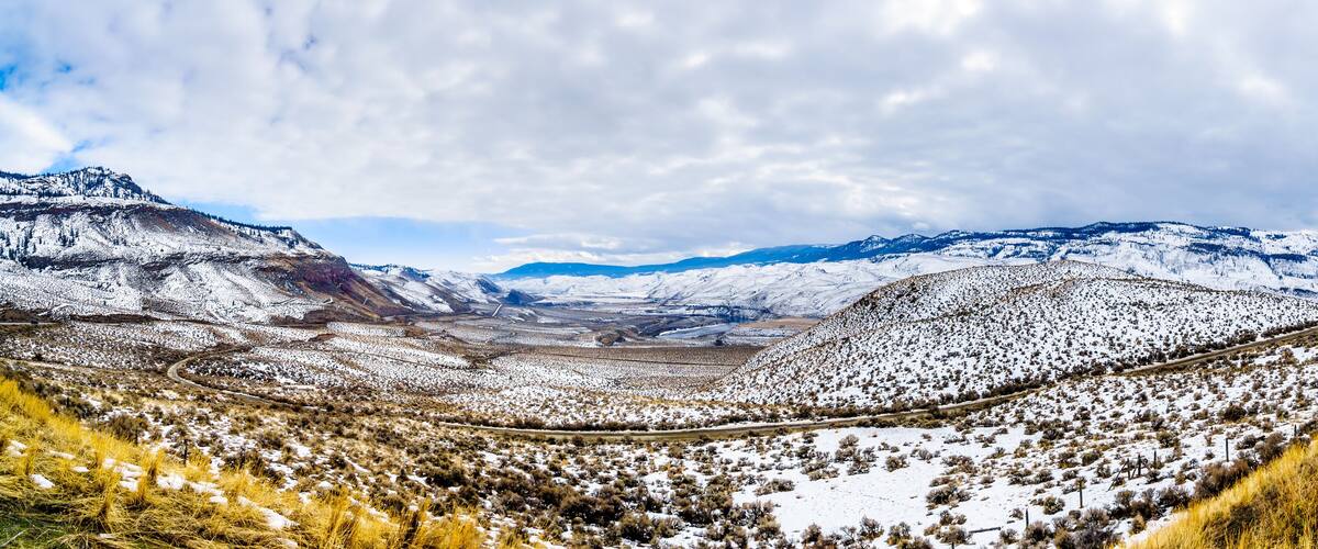 A snow-covered mountainous landscape with a winding road.