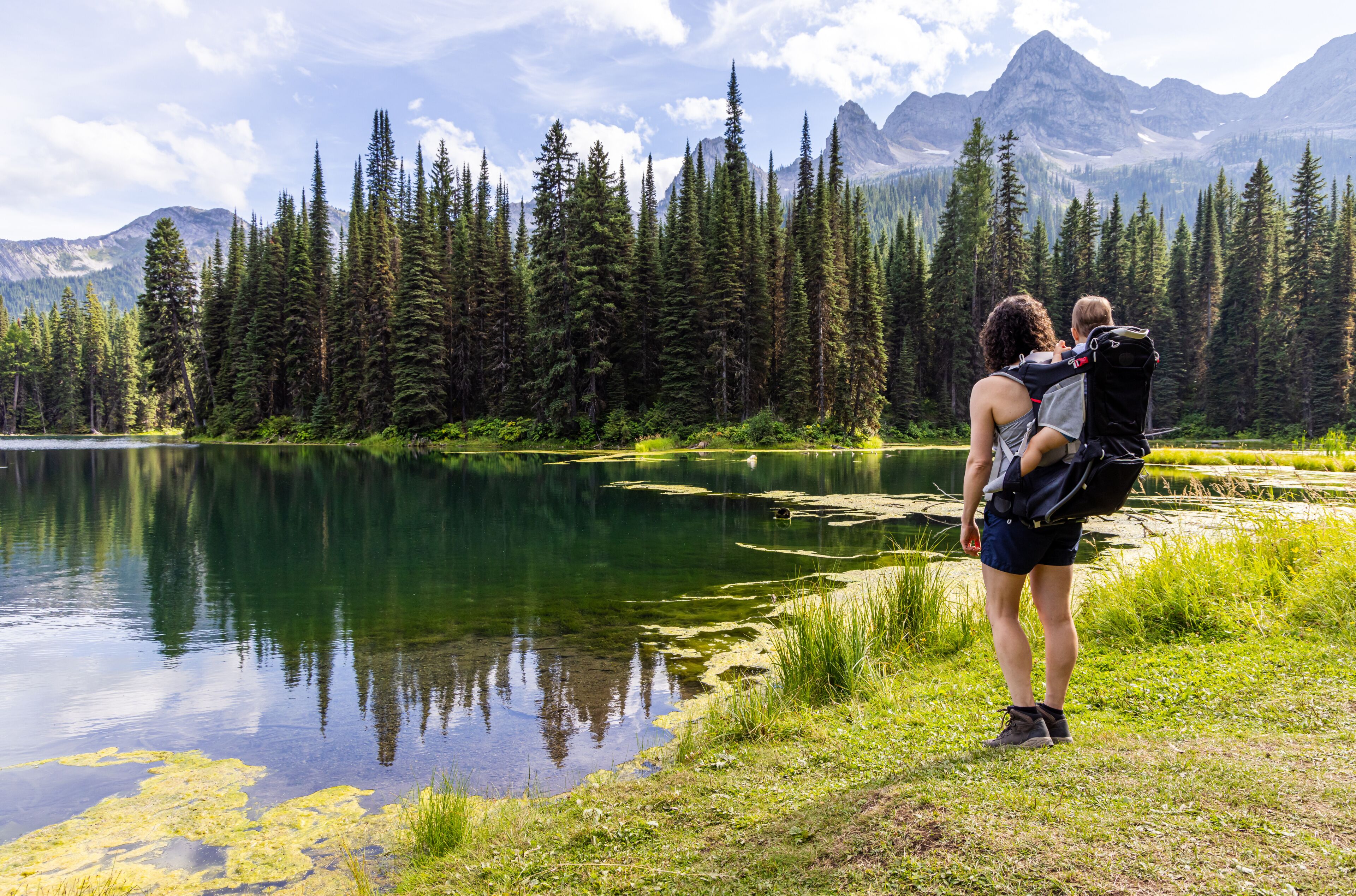 A lake surrounded by dense forest and mountains.