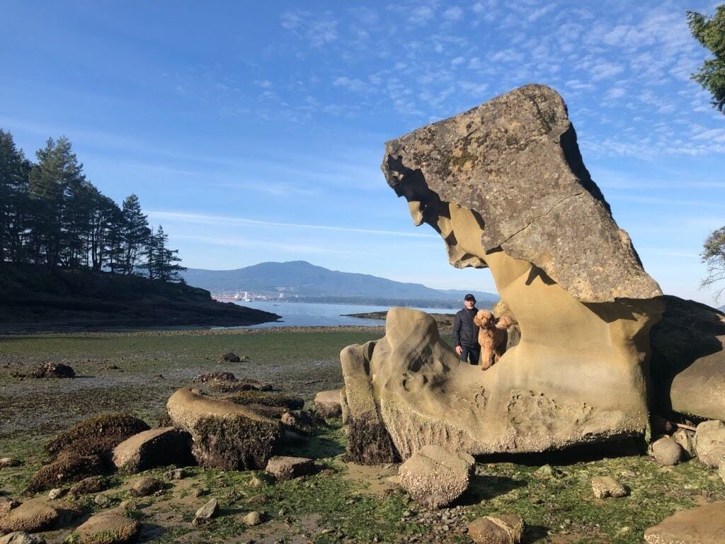 A large rock formation with a person standing on it.