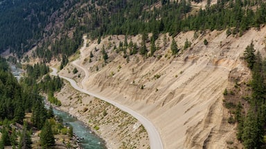 Aerial View of a Scenic Dirt Road towards Gold Bridge in the Valley surrounded by Canadian Mountain Landscape. Taken near Lillooet, British Columbia, Canada.