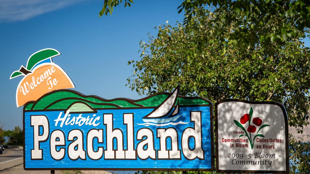 Schild für Historic Peachland mit Segelboot und einer Willkommensbotschaft.
