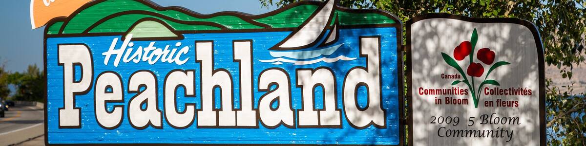 Schild für Historic Peachland mit Segelboot und einer Willkommensbotschaft.
