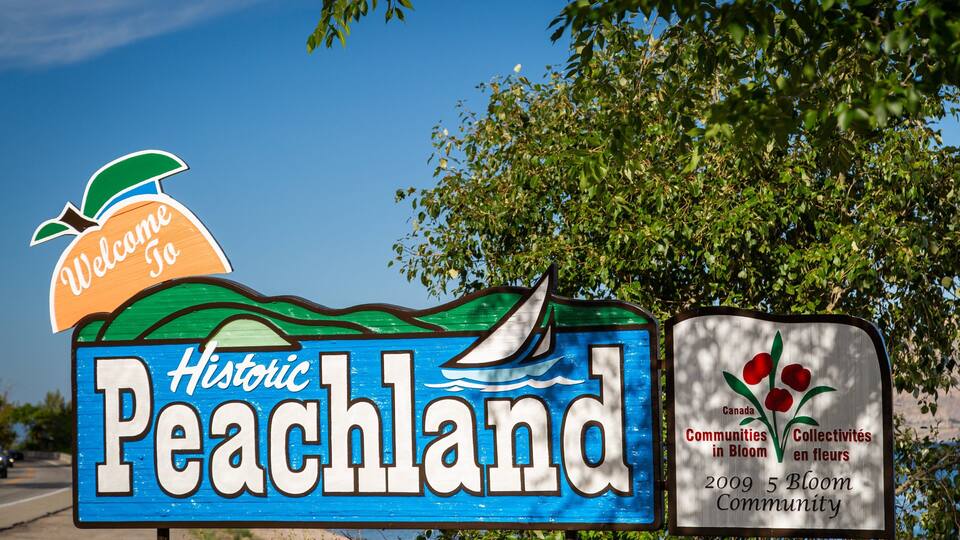 A sign for Historic Peachland with a sailboat and a welcome sign.