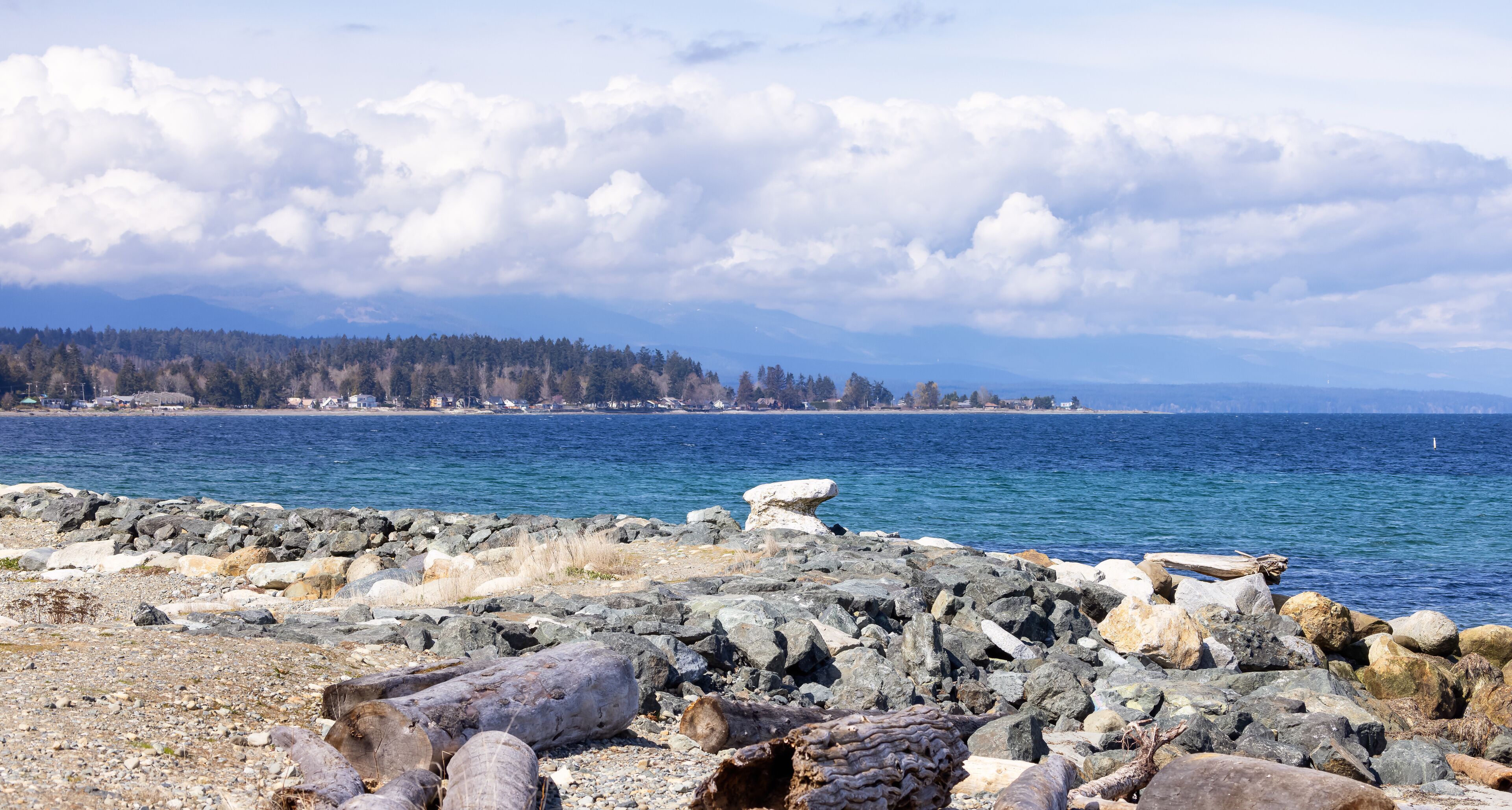 Rocky Shore in Qualicum Beach, Vancouver Island, British Columbia, Canada. Sunny Cloudy Day.