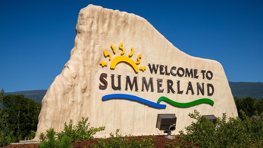 Un gran cartel de bienvenida a Summerland con un diseño de sol y olas.