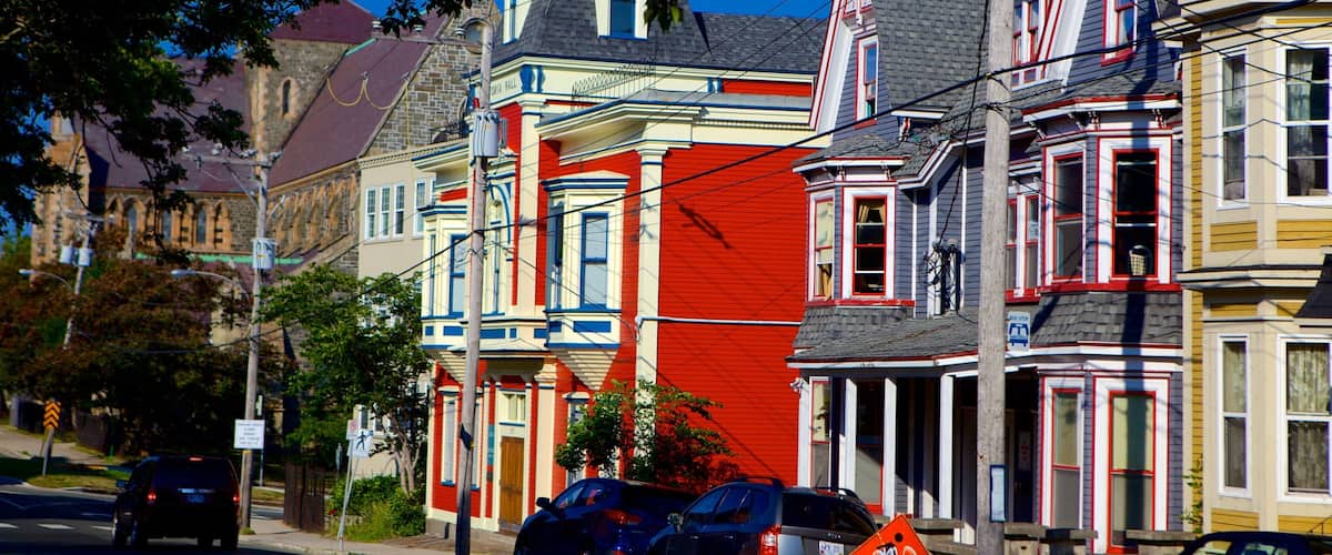 Colorful Victorian houses with a street and cars.