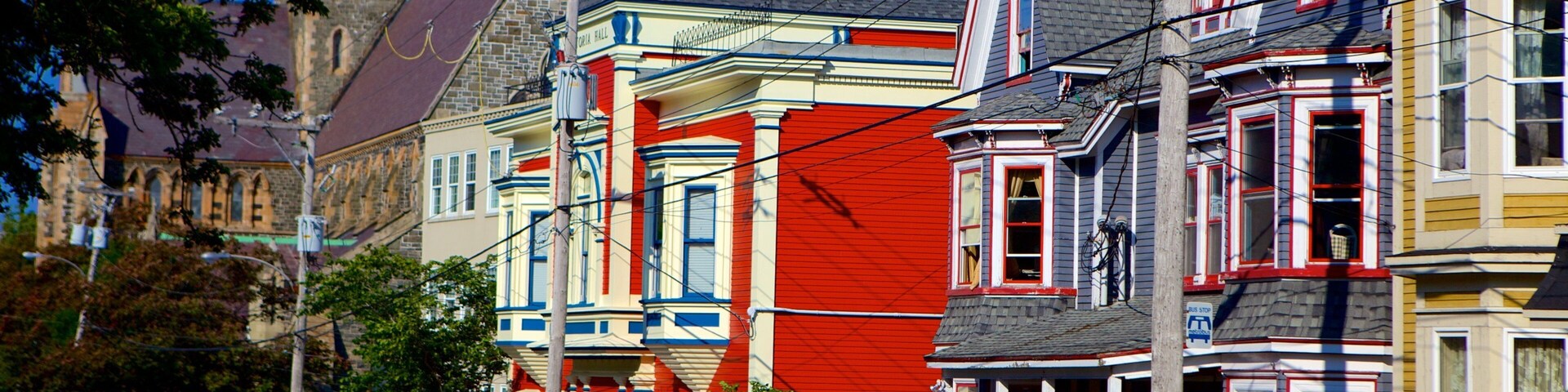 Colorful Victorian houses with a street and cars.