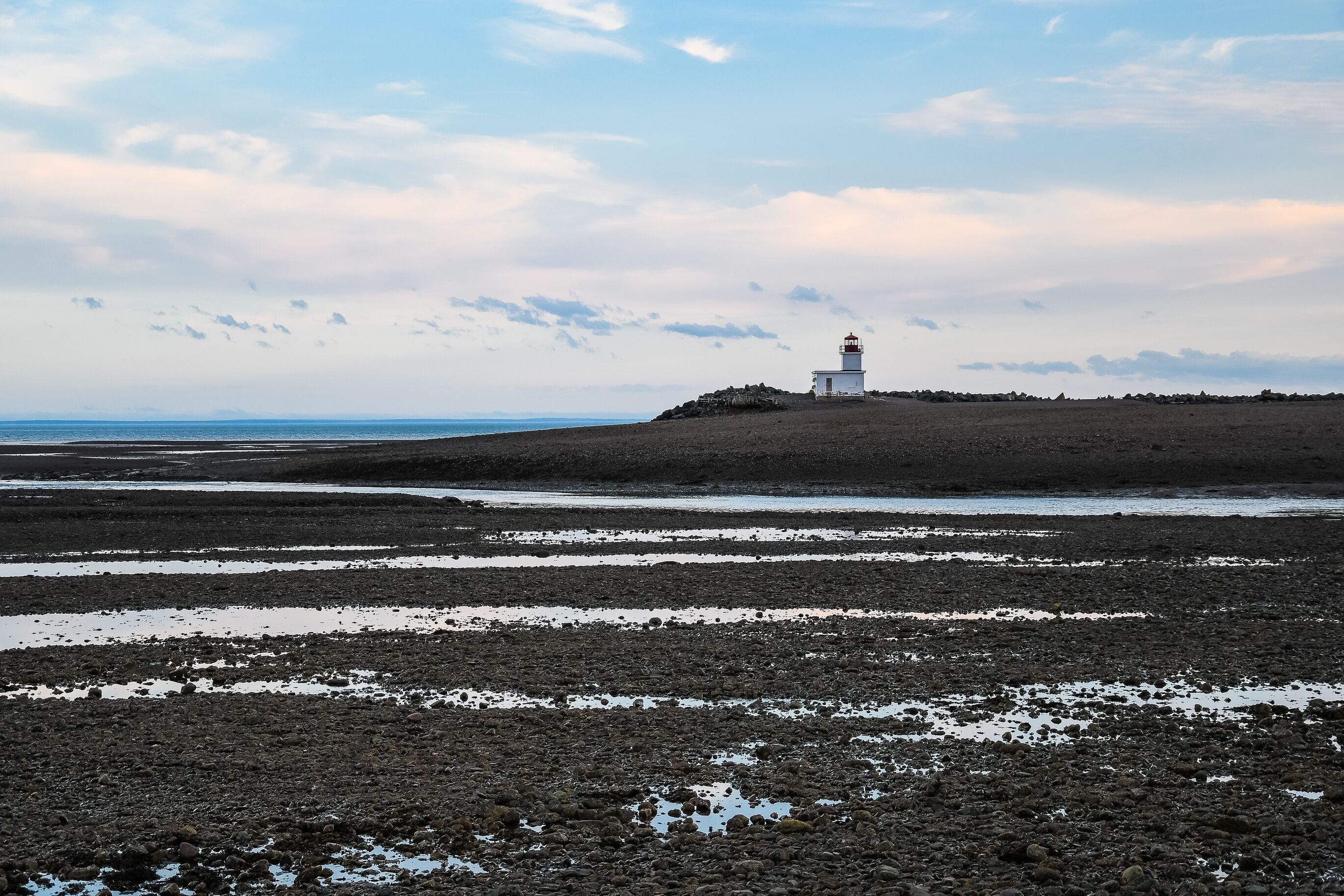 Un phare situé sur un promontoire rocheux, offrant une vue sur la côte.