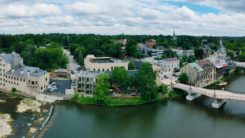 A riverside town with a bridge, buildings, and a church steeple.