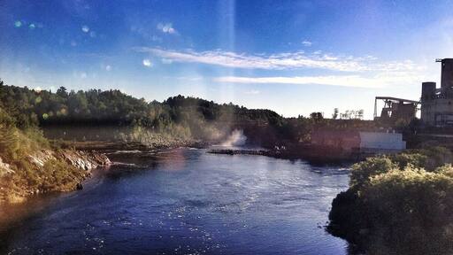 Hard to see in the distance but there's a cool dam way back.
I tried to get a shot of the massive factory beside it - but was blurry through the window.
So far I've counted 4 waterfalls and several dams along the Trans-Canada Hwy. also seen a beautiful hawk sitting atop a hay pile (would have made a great photo, and a few Hurons.
Anyone taking this trip with Greyhound Busses, a word of caution - Sudbury station is very sketchy, no coffee, dirty washrooms, vending machines only, and your in the middle of no where with homeless walking around. Keep an eye in your belongings at all times.
Almost approaching Sault Ste Marie Ontario (where I was born). Ironic enough I haven't lived here since I was a toddler and now I'm back on my birthday. Kinda cool I think.