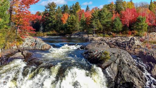 Panoramic view of the wild river flowing amidst rugged rocks and beautiful fall leaves, Massey, ON, Canada