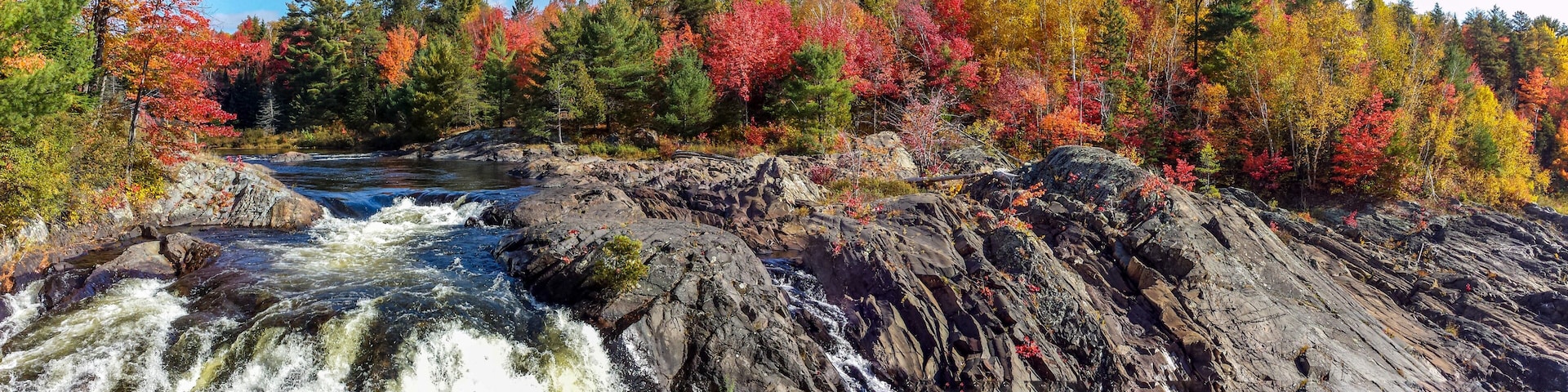 Panoramic view of the wild river flowing amidst rugged rocks and beautiful fall leaves, Massey, ON, Canada