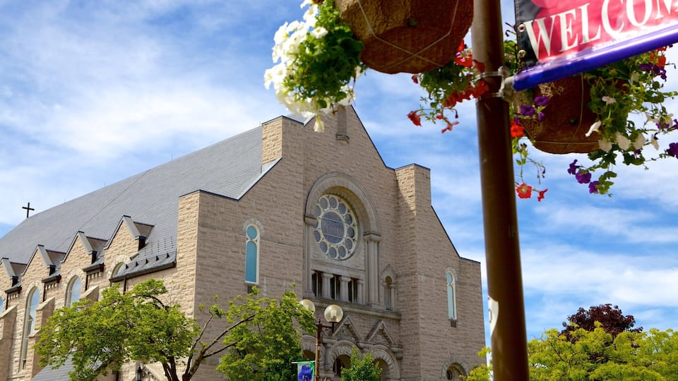 A church with a large arched window and a cross on the roof.