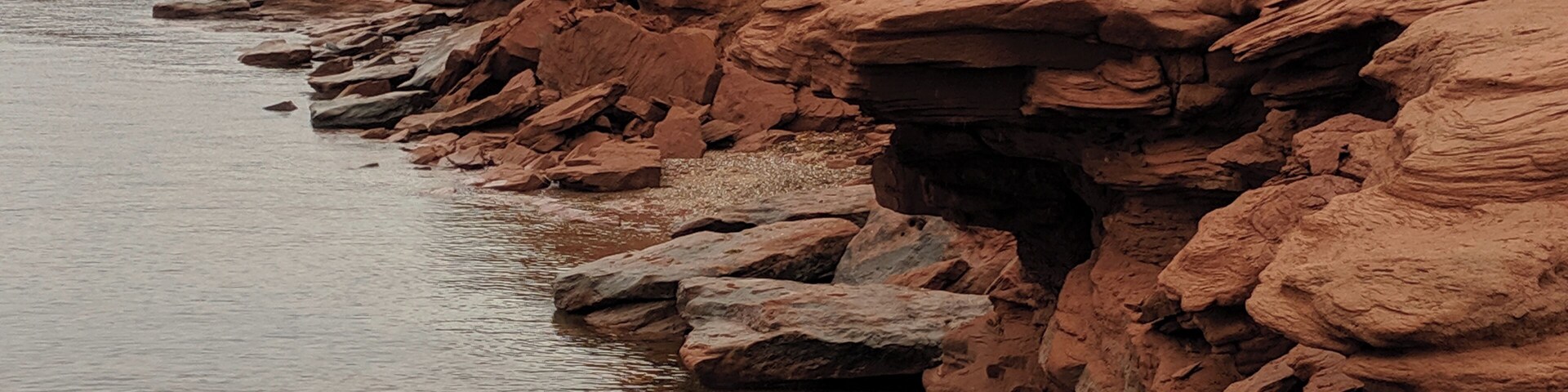 A rocky shoreline with a river.