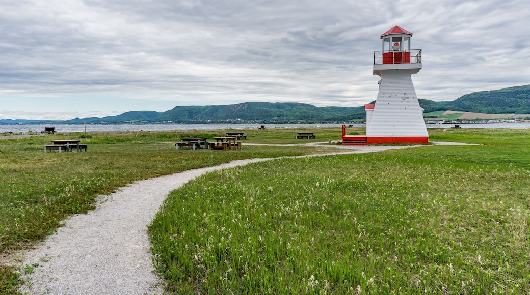 View on the small but cute Carleton's lighthouse with a view on the Mount St Joseph in the background, located in Quebec, Canada