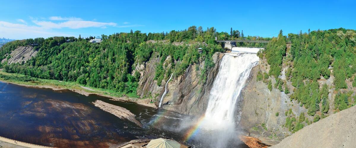 A large waterfall, a river, and a forested hillside.