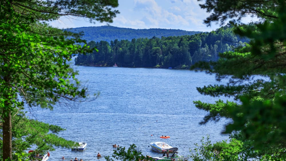 Lac-Simon, Quebec, Canada – July 29, 2018: Amazing view of Lac-Simon sightseeing resort. Lake beach, mountain and hills landscape with beautiful skyline.