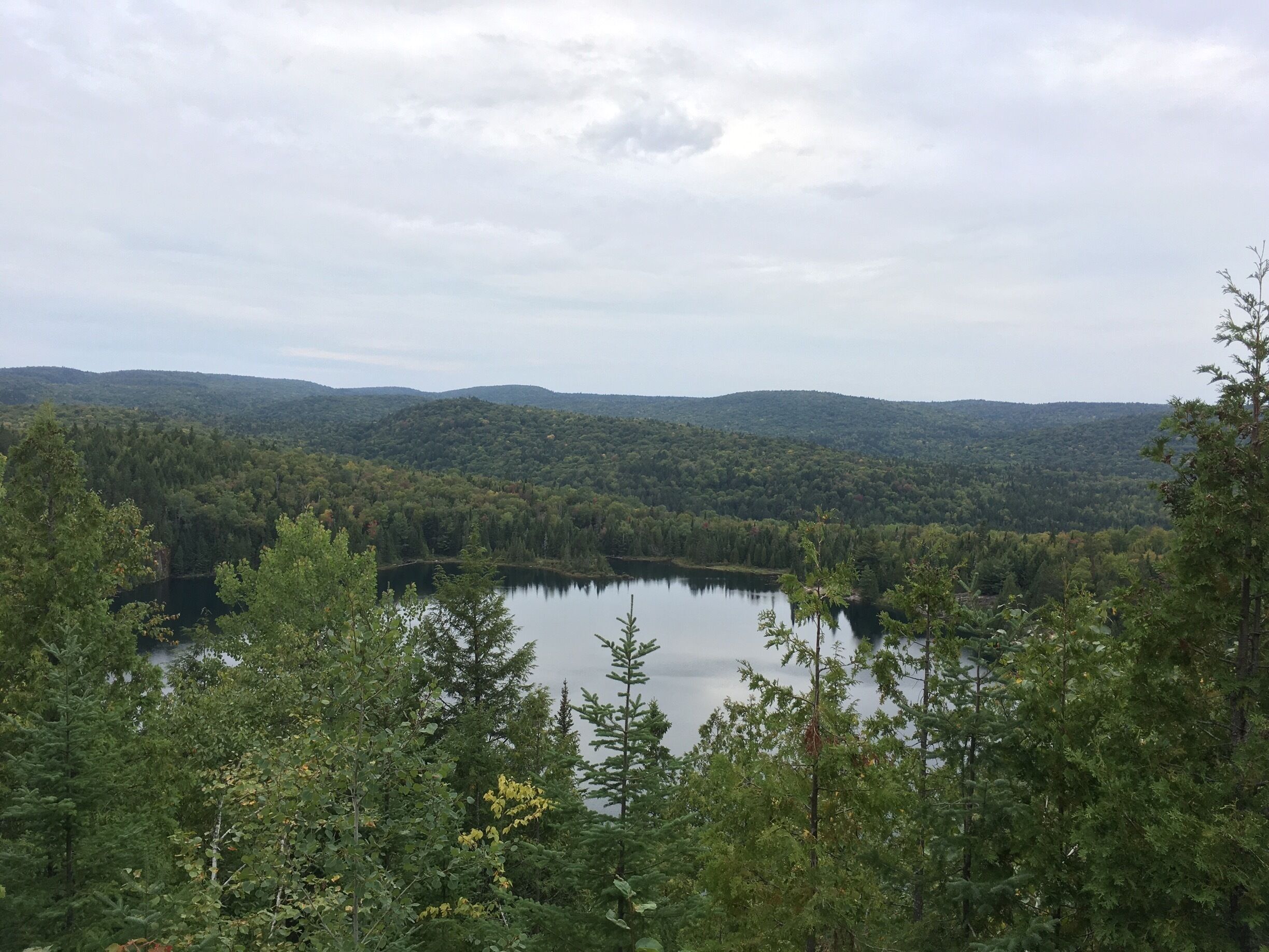 A lake surrounded by dense forest and hills.