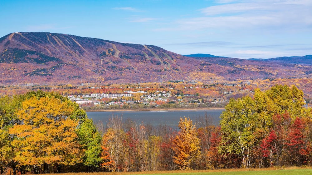 View from Ile d'Orleans of Saint-Lawrence river and Saint-Ferreol-les-Neiges village with Mont-Sainte-Anne in the background in autumn., Quebec, Canad
