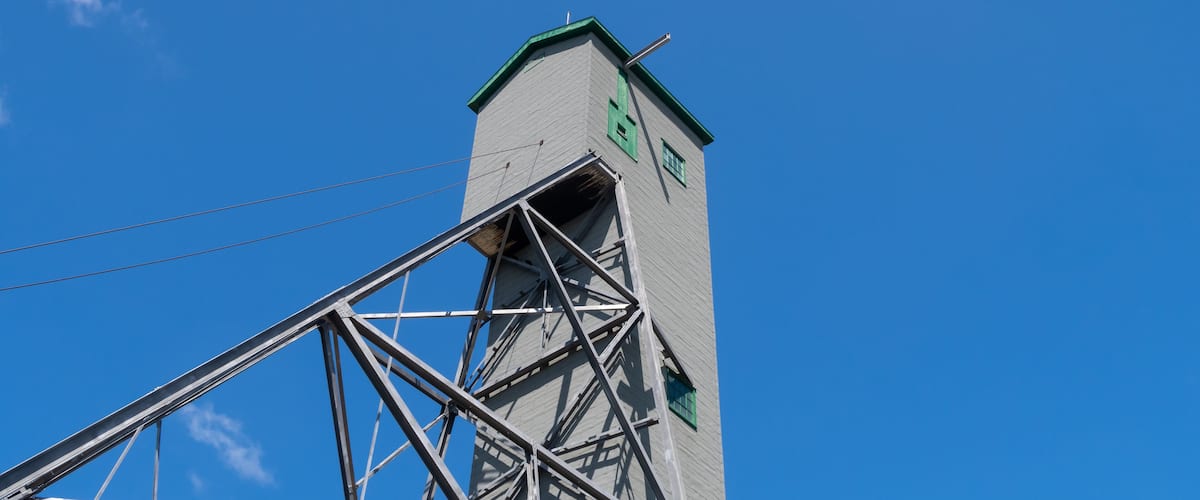 A tall building with a green roof and a metal framework.