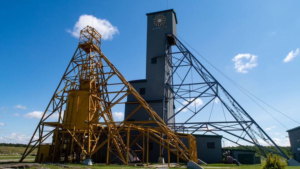 A large industrial structure with a prominent tower and a yellow crane.