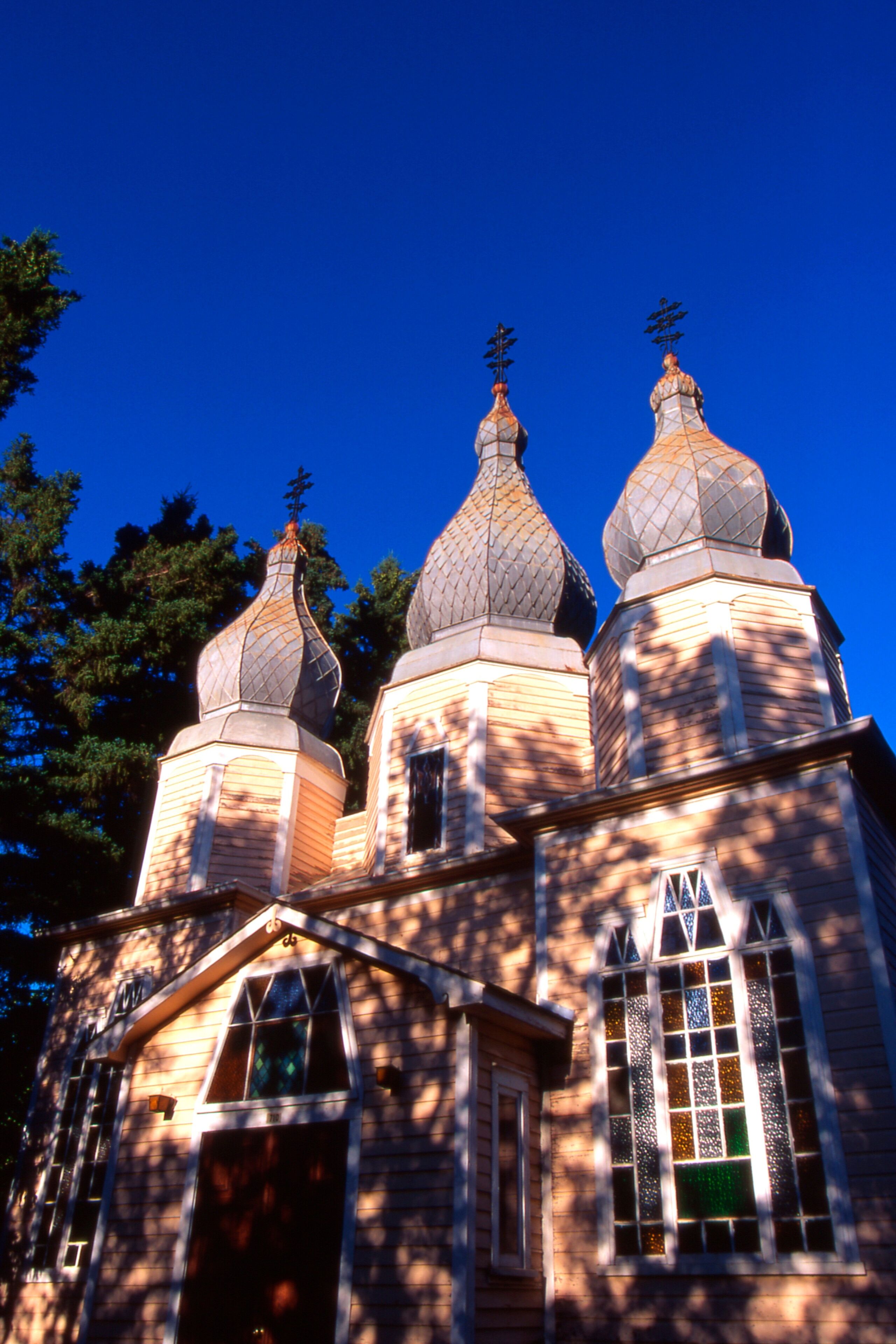 A church with three domes and a cross on top.