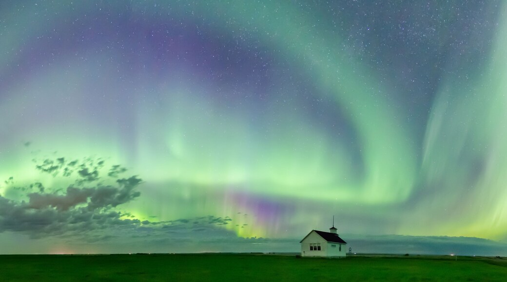 Swirl of Aurora Borealis Northern Lights over the historical North Saskatchewan Landing school established in 1914 near Kyle, Saskatchewan, Canada