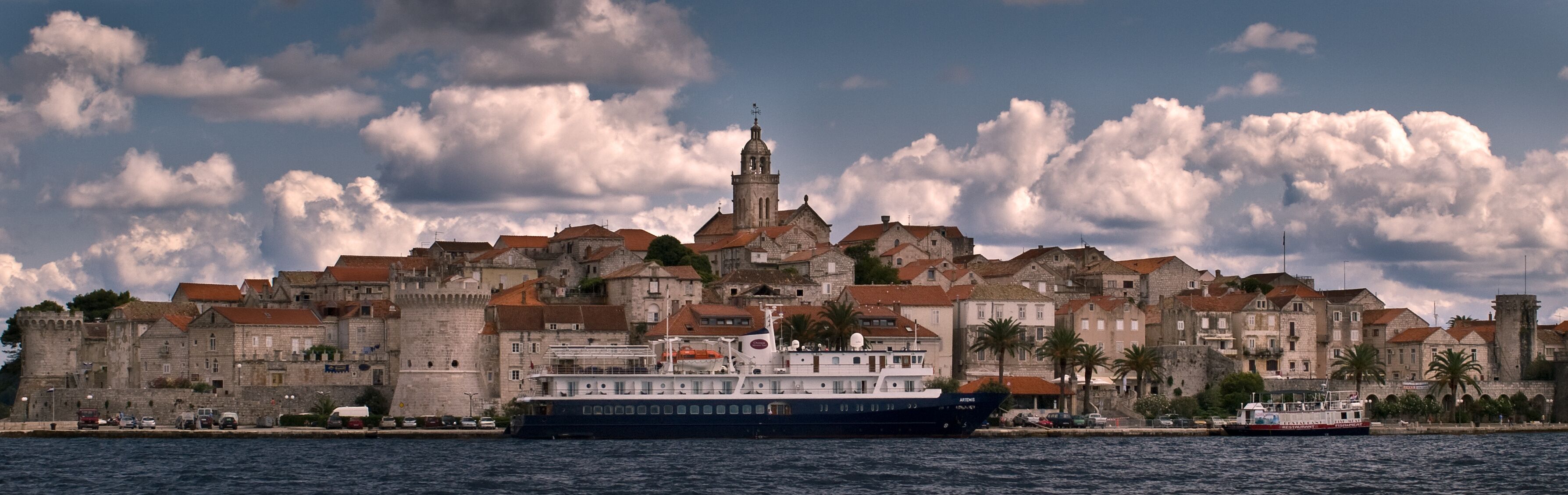 Seaview of a fortified city with sky and clouds.