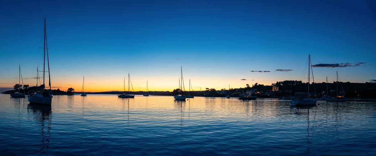 Panorama view of Yachts moored on buoys near the shore in the bay of Uvala Gradina near the town of Vela Luka on the island of Korcula at night time in Croatia