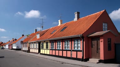 A row of traditional houses with red-tiled roofs and a clear blue sky.