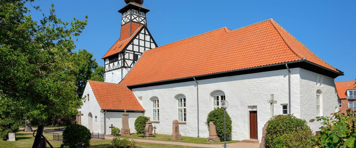 A church with a red-tiled roof and a tall steeple.