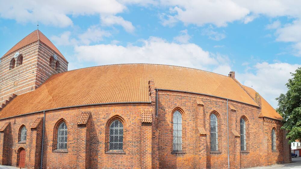 A brick church with a round dome and a bell tower.