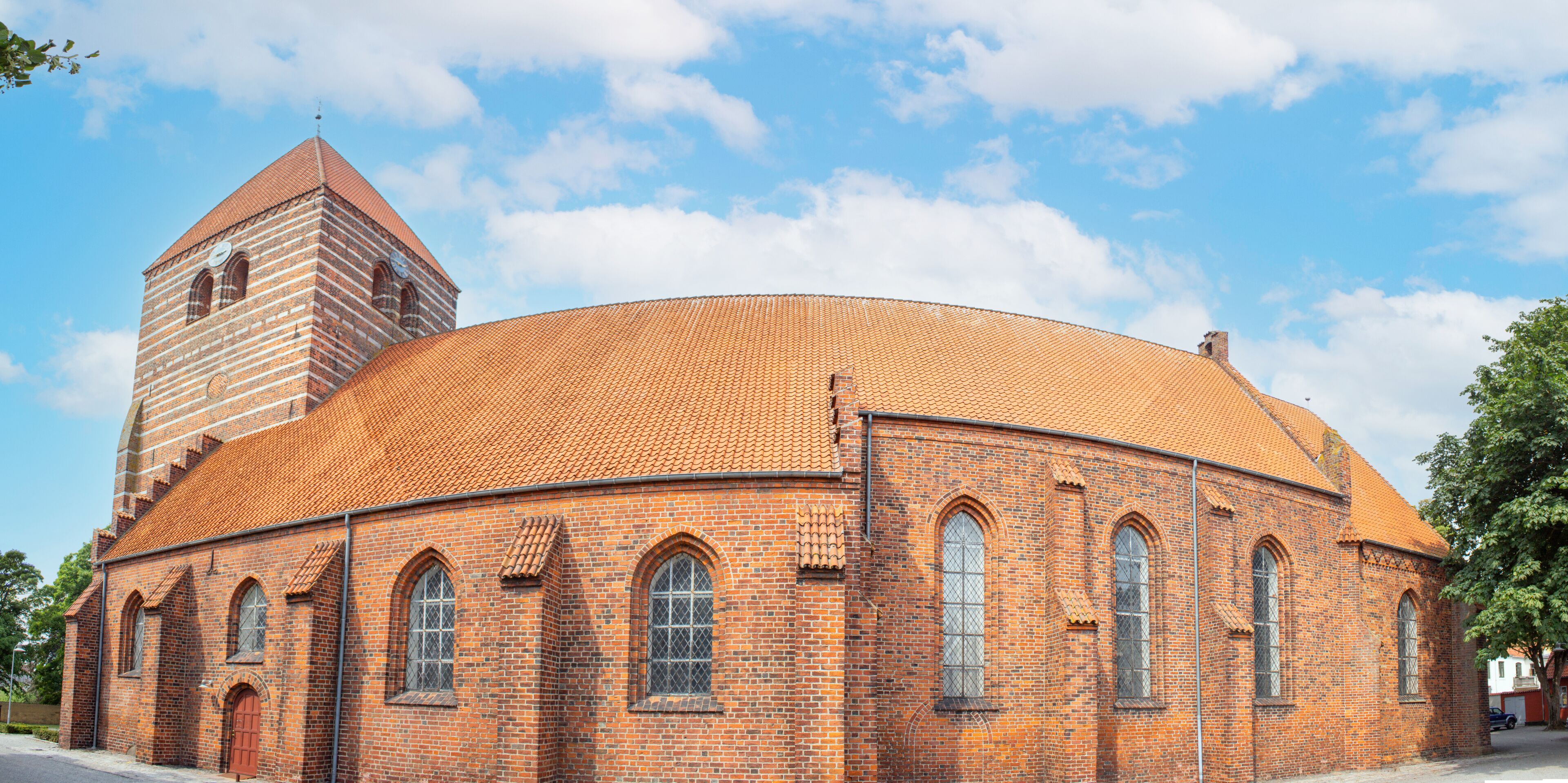 A brick church with a round dome and a bell tower.