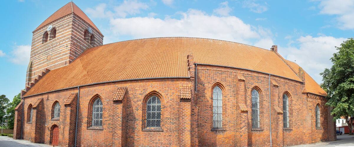 A brick church with a round dome and a bell tower.