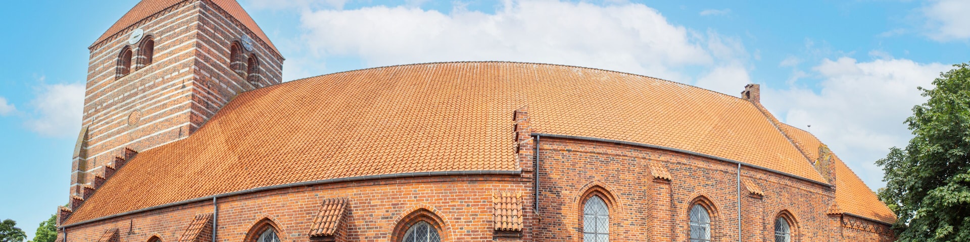 A brick church with a round dome and a bell tower.