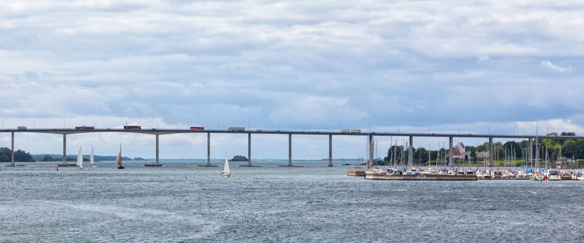 A bridge over a body of water with sailboats and a marina.