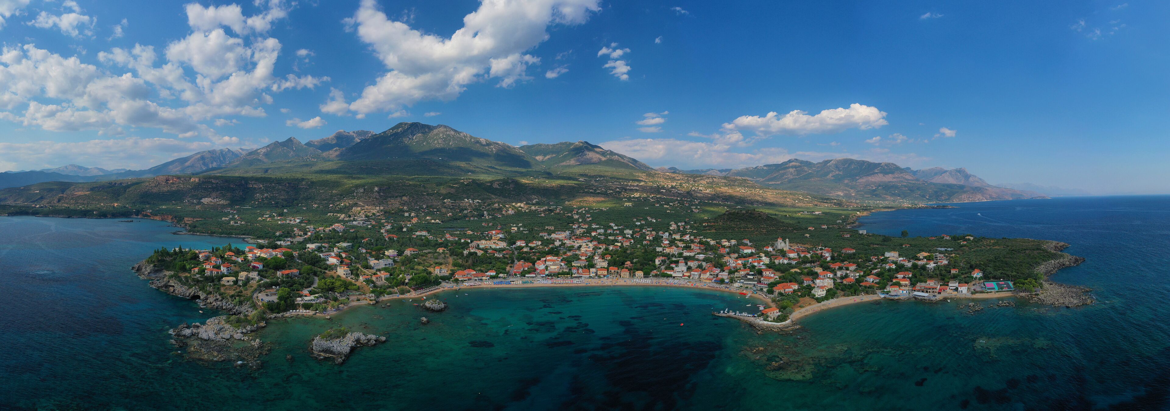 Aerial drone panoramic photo of iconic picturesque village and sandy beach of Stoupa in the heart of Messinian Mani, Peloponnese, Greece