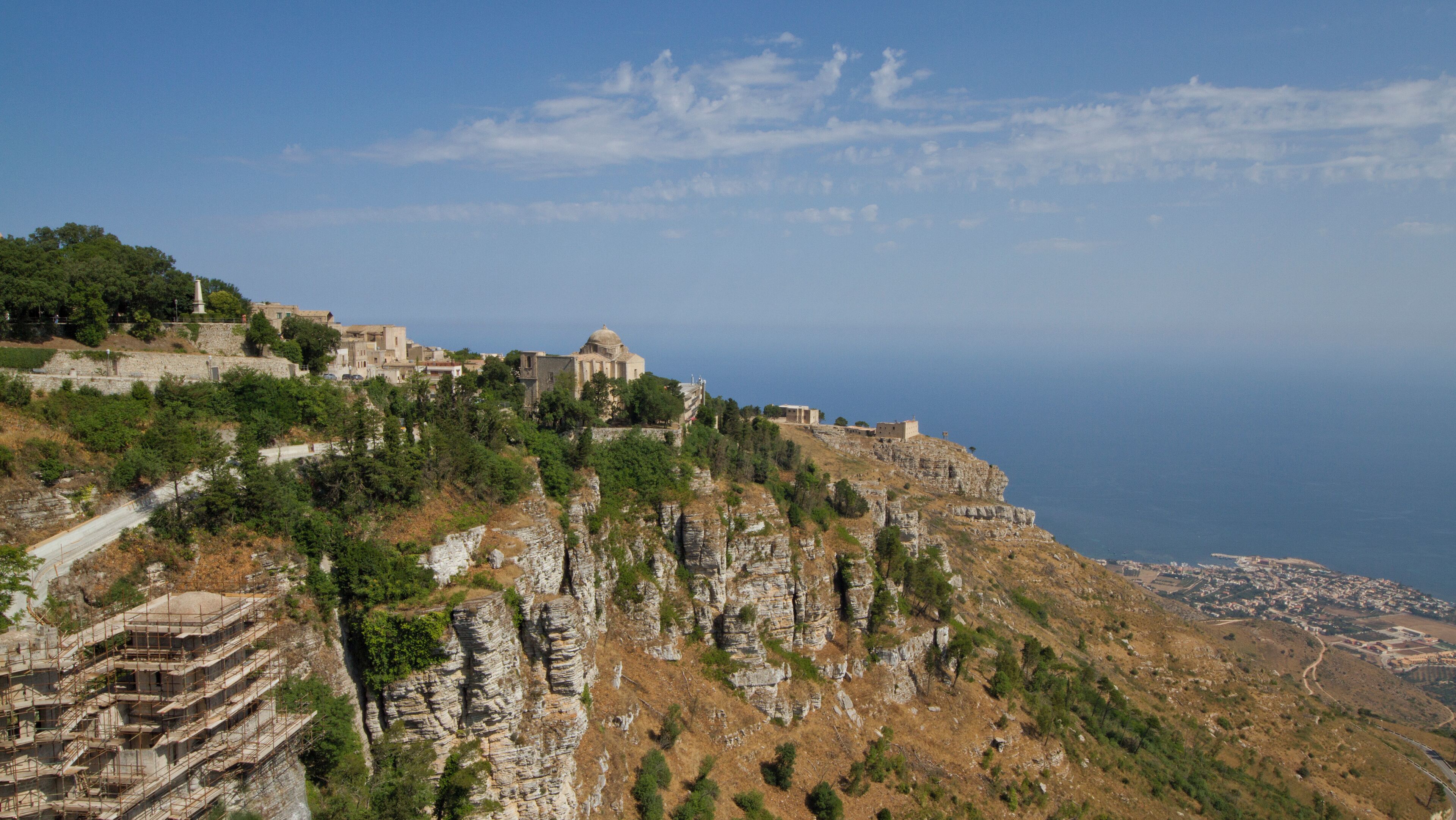 A coastal town with historic buildings perched on a cliff overlooking the sea.