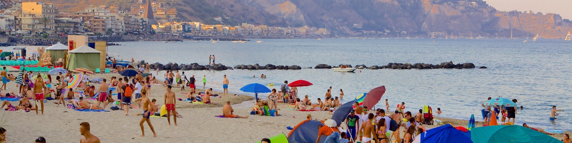 Giardini Naxos which includes a beach as well as a large group of people